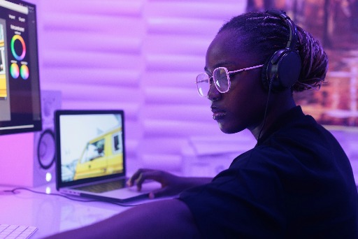 Team member working on a laptop with headphones